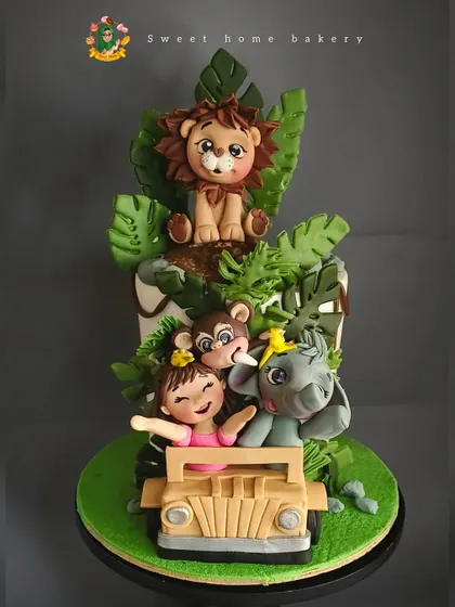 Welcome to the jungle! This safari-themed cake was made for Falyn's second birthday. It features a little girl on a jeep adventure with her friendly lion, monkey, and elephant pals, all handcrafted from fondant and surrounded by lush, edible leaves.