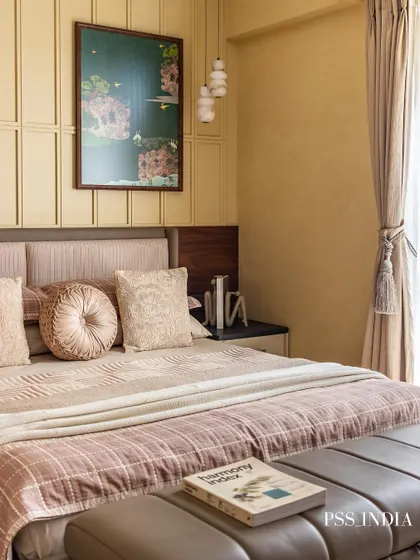 This bedroom is a sanctuary of warmth and comfort. The paneled wall, layered bedding in dusty rose and beige, and a statement art piece come together to create a space that invites you to rest and recharge.