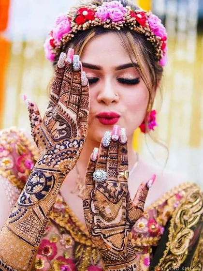 This bride looks absolutely stunning with her full bridal mehandi. The design complements her festive look perfectly.