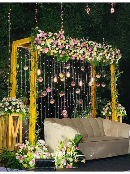 A full view of the enchanting Jayamala stage, with its beautiful floral arrangements and magical lighting. The plush sofa provides a comfortable and elegant spot for the couple.