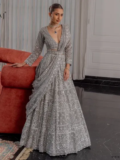 A shimmering statement of regal charm. This intricately hand-embellished silver lehenga from the 'Ruvaah' collection features exquisite zardosi and mirror work.