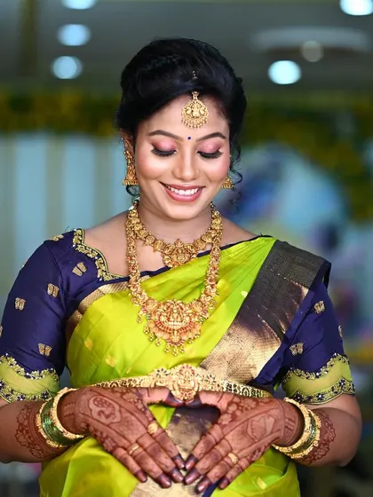 The complete look for a traditional seemantham. The rich stain of the mehendi on her hands beautifully highlights her festive attire and the joy of the occasion.
