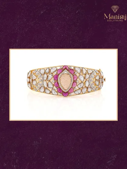 A blend of bold beauty and timeless charm. This handcrafted kada (bangle) features Polki diamonds and vibrant ruby-pink accents around a beautifully carved center stone. It's a piece designed to stand out.