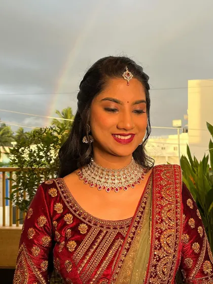 The bride is glowing in her velvet lehenga. The makeup features a classic red lip and soft eye makeup that perfectly complements the rich fabric.