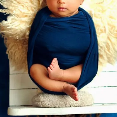 This unique pose, often called the 'hanging pose', is done with the utmost care and safety as a composite image. It beautifully showcases the baby's tiny curled feet and body.