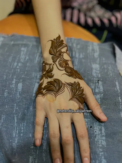 A simple and elegant leaf-based design on the back of the hand, perfect for a minimalist look.