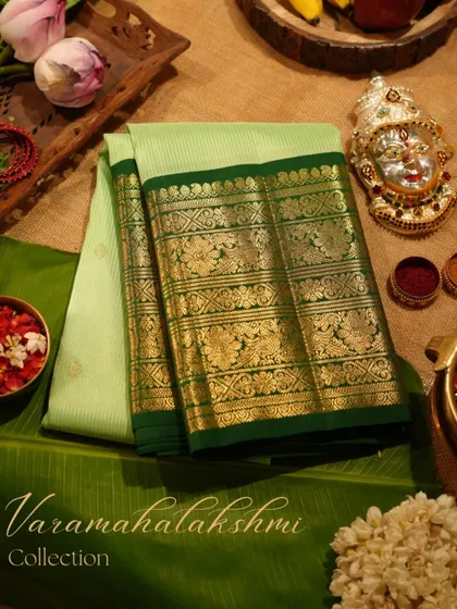We believe every festival deserves a touch of grandeur. This stunning Kanjivaram in shades of green, styled with traditional puja elements, embodies the spirit of celebration and our rich cultural heritage.