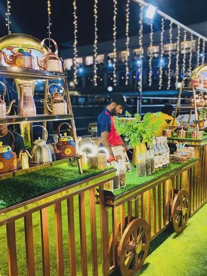 The full tea and coffee station, designed as a rustic cart with elegant lighting.