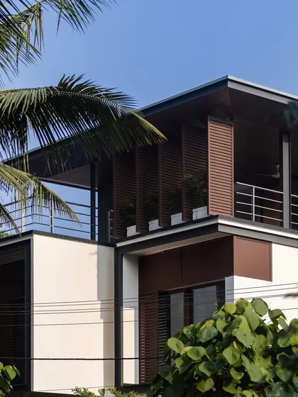 Exterior views of the Mango Tree Yard home, highlighting its contemporary form, clean lines, and the use of screens for privacy and ventilation.