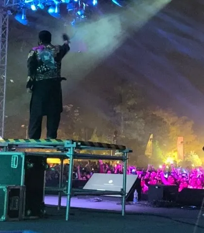 A shot from behind, showing me on a raised platform overlooking a massive festival crowd with full stage lighting. This perspective highlights the scale of the events I play.
