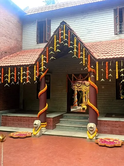 A welcoming entrance to a traditional house, adorned with classic marigold garlands for a wedding celebration.