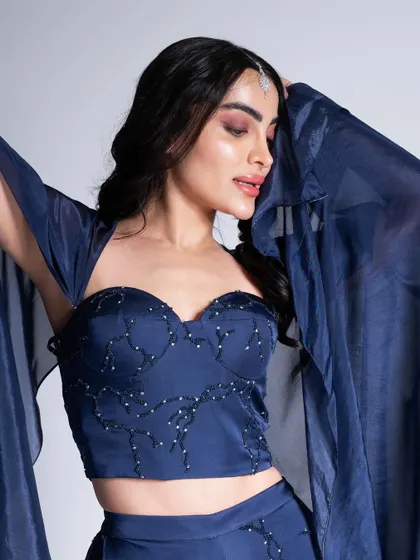 A deep blue bustier set paired with a sultry smokey eye. This look is perfect for an evening event, with a focus on dramatic eyes and glowing skin.