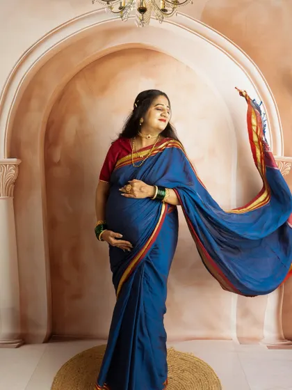 A graceful shot with the saree's pallu tossed to create a sense of movement. This technique adds a dynamic element to traditional portraits.
