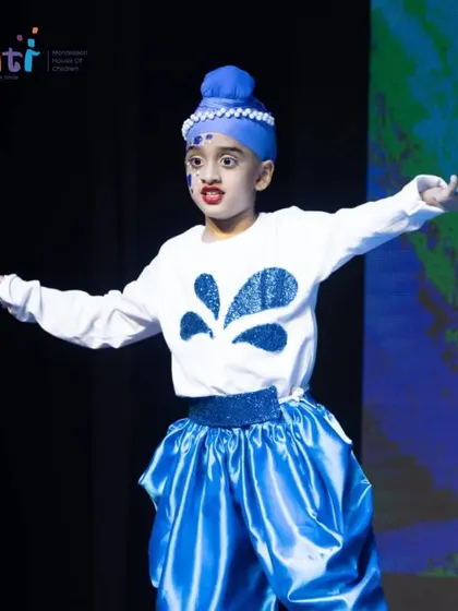 A boy in a blue turban performs an energetic dance, representing the powerful flow of water.