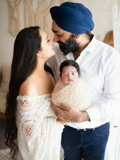 A classic portrait of new parents with their newborn, capturing the love and awe of this special time.