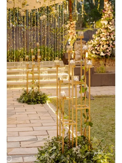 The entrance to the Sangeet is just as glamorous as the main event. Golden candle stands and lush greenery line the path, welcoming guests to a night of rhythm and glitz.