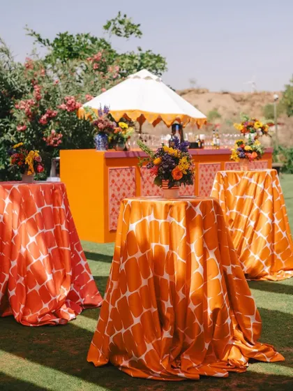 An overview of an Indian bazaar-style bachelorette party, featuring brightly colored linens, a festive bar, and lush green surroundings. The theme is vibrant, playful, and perfect for a fun-filled celebration.