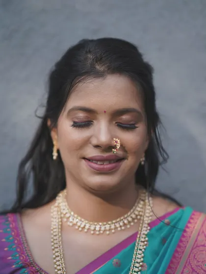 Eyes closed, this bride radiates serenity. This shot highlights the soft, shimmery eyeshadow and the overall peaceful glow of her makeup.