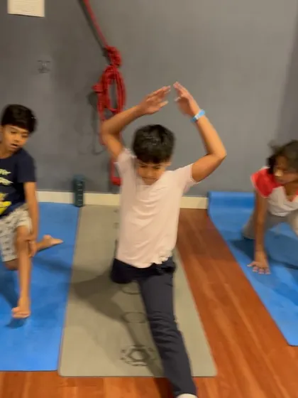 A young student works on his Hanumanasana (splits) in a dynamic way, showing great enthusiasm.