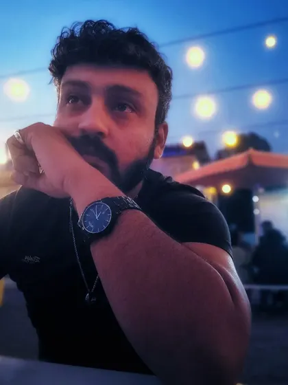 A moody self-portrait against a bokeh background at dusk.