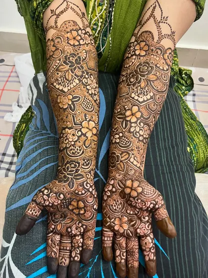 A full view of a recent bridal mehndi, with dense floral patterns covering the hands and arms.