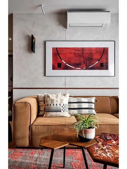 The living room's cement-finished walls provide a neutral, textured backdrop for the warm brown sofa and a striking piece of red abstract art.