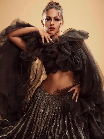 A showcase of high-fashion artistry with a dramatic black tulle ensemble. The makeup is powerful and sculpted, featuring a strong eye and defined features, ideal for a bride wanting a bold, avant-garde statement for her pre-wedding shoot or reception.