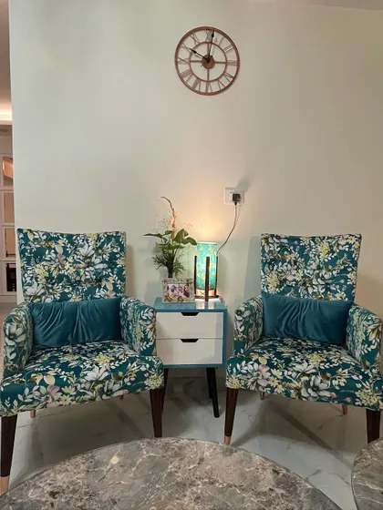 Details make the design. These high-back armchairs with a vibrant floral print add a touch of personality and sophistication to the living room, creating a perfect corner for conversation or a quiet read.