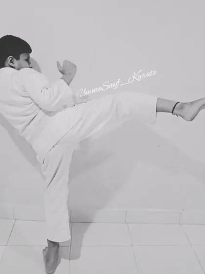 "You can be the greatest, you can be the best!" A young white belt student practicing his kick, full of potential and determination.