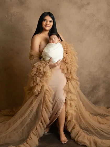 A stunning portrait of a new mother in a beautiful gown, holding her precious newborn. These sessions are a wonderful way to celebrate motherhood.