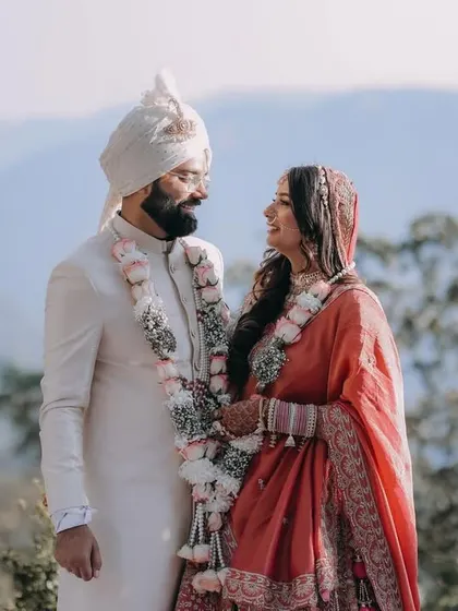 A stunning portrait of the couple against a backdrop of mountains, taken on their wedding day.