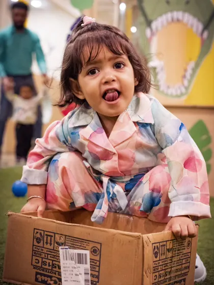 A playful moment from a preschool carnival. Capturing the personality of each child, like this little girl's cheeky expression, is what makes event photography so special.