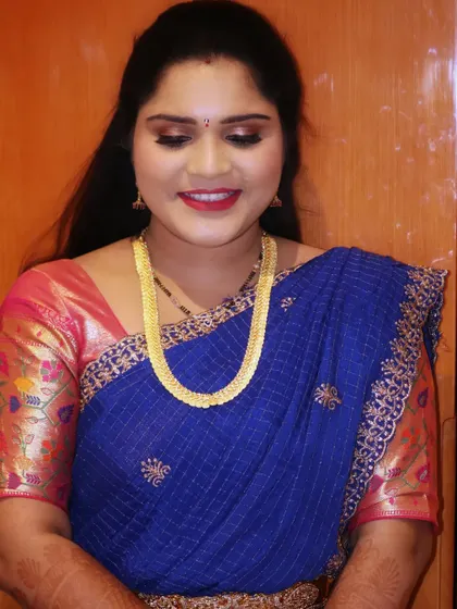 A simple and elegant makeover for a family member. The makeup is kept soft and natural, with a classic red lip that adds a pop of color to her blue silk saree.