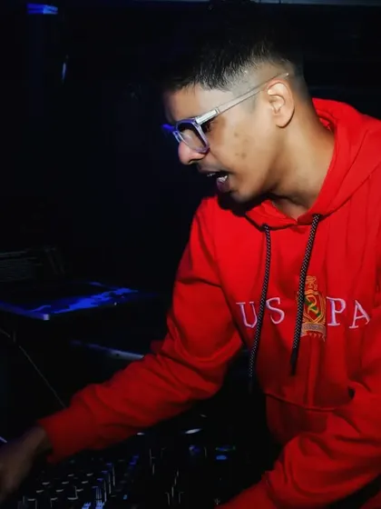 In a red hoodie, deep in concentration, making sure the music keeps people on the floor.
