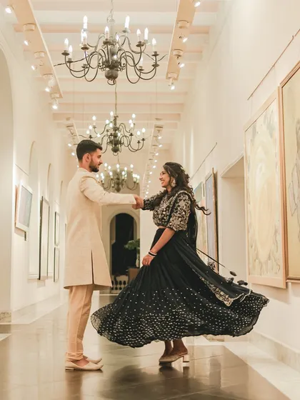 A couple shares a dance in a beautiful art gallery corridor at the Lalitha Mahal Palace, a unique and elegant reception venue.