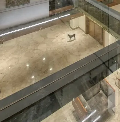 A view looking down through the glass bridge, showing how it creates visual connections between different floors.