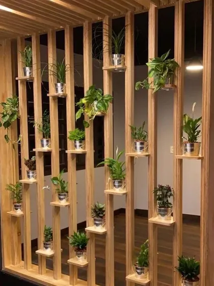 This wooden structure acts as both a room partition and a vertical garden. The open slats maintain a sense of space, while the built-in shelves are perfect for displaying a collection of small potted plants.