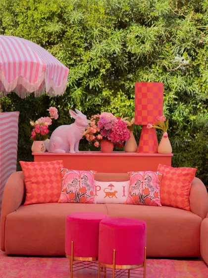 This whimsical lounge featured a pink sofa, a checkerboard lamp, and a quirky white rabbit sculpture, all tied together with custom-printed cushions.