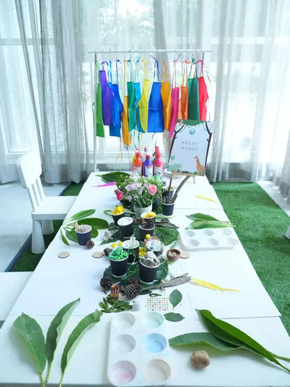 We believe in parties that engage all the senses. This nature-inspired art station, complete with colorful aprons and natural materials, was set up for little guests to create their own jungle masterpieces.
