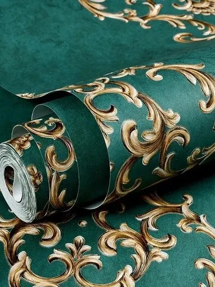 A close-up of a deep green wallpaper roll with a luxurious, embossed gold damask border design.