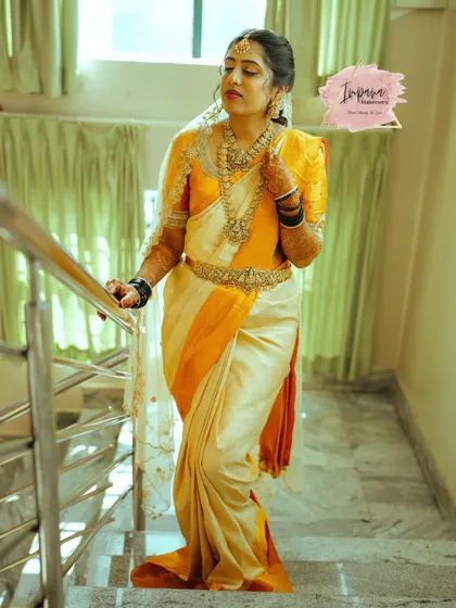 This full-length shot showcases the entire bridal ensemble. The perfectly draped Kanjeevaram saree, combined with the elegant hairstyle and makeup, creates a stunning silhouette.
