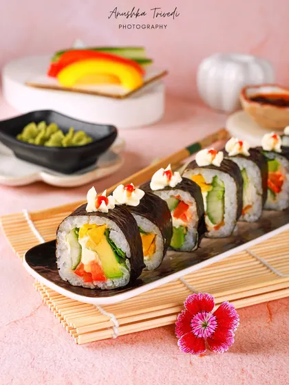 The full line of vegetable sushi rolls, garnished with mayonnaise and sriracha, looking ready to eat.