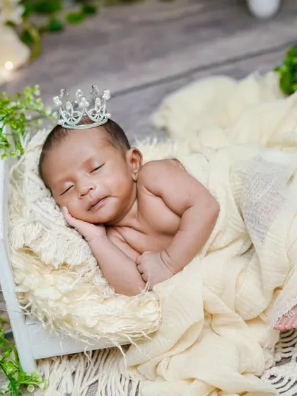 A royal slumber. The combination of the rustic wooden floor, a simple white crate, and a tiny crown creates a beautifully understated and elegant portrait.