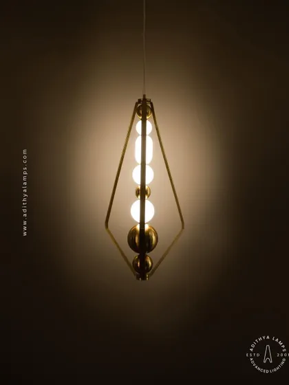 This elegant pendant is framed by a triangular gold structure, enclosing a string of white and gold beads. It's a sophisticated and modern piece that adds a touch of jewelry-like decoration to your space.
