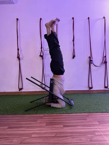 A supported headstand using a chair. This variation takes pressure off the neck and shoulders, making inversions more accessible.