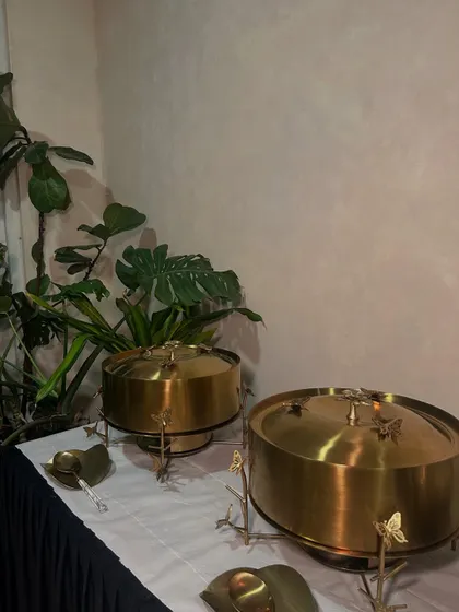Our elegant, butterfly-adorned brass chafing dishes, part of our commitment to providing a full-service luxury experience.