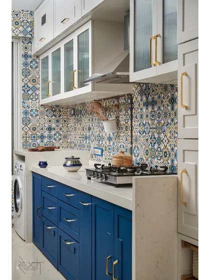 A full view of the kitchen, showing the ivory overhead storage, Moroccan tile backsplash, and royal blue base cabinets.
