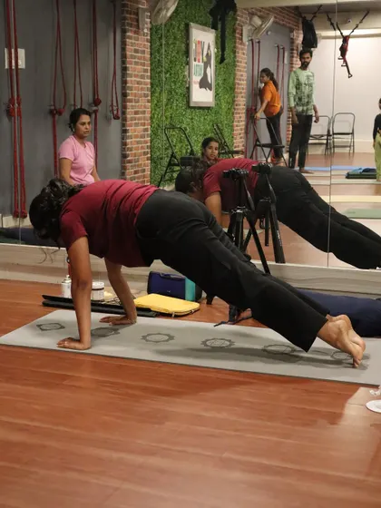 A student holds a strong plank pose, building the foundational strength necessary for more advanced asanas.