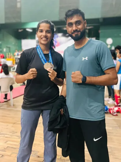 Another proud coach-student moment, celebrating a significant achievement at the state championship. This partnership is key to turning potential into performance.