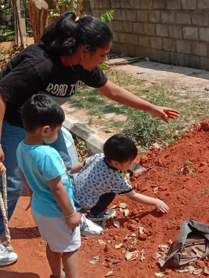 On a walk, children collect different types of soil to compare textures and colors for our gardening project.